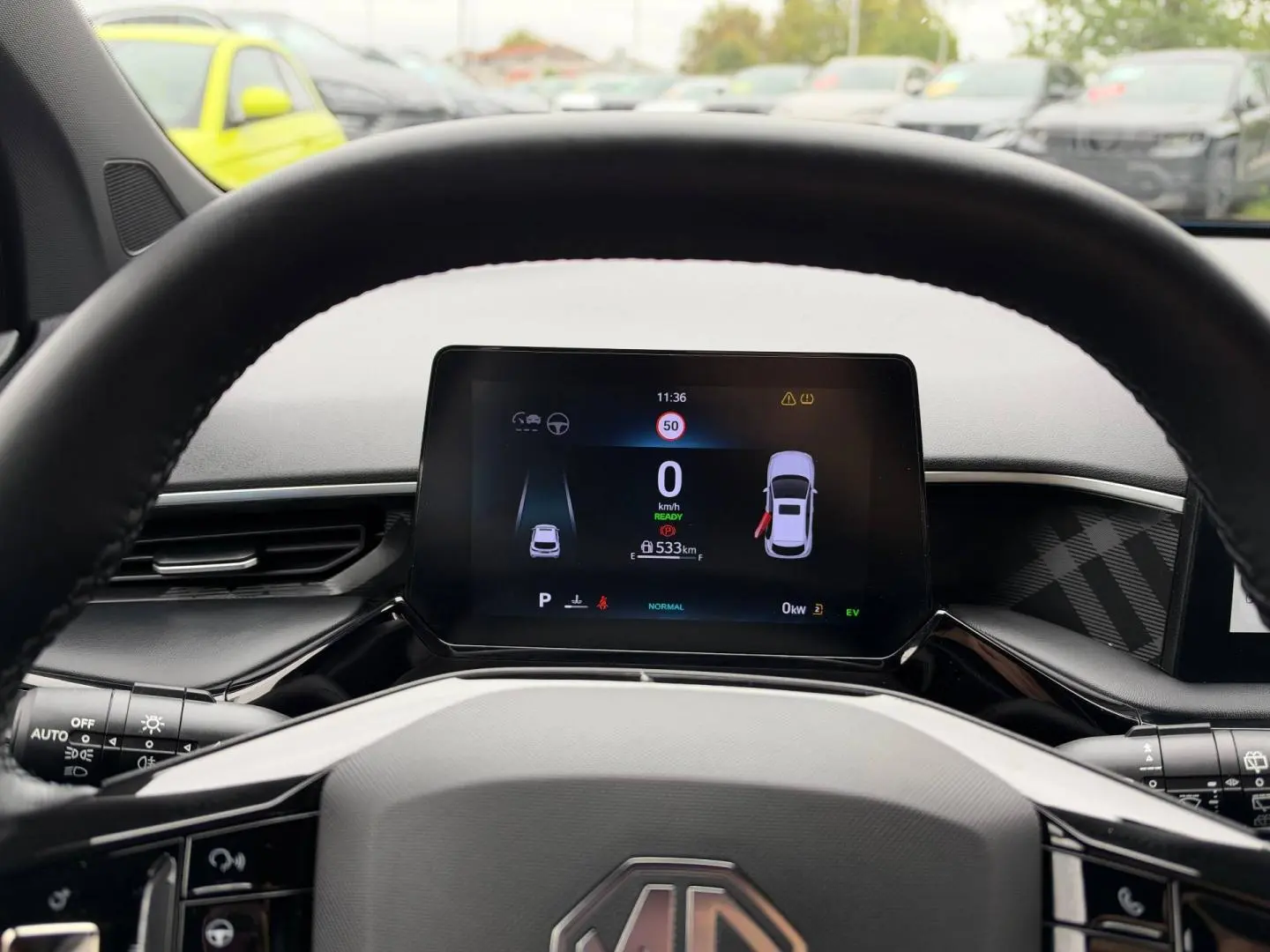 Vue depuis le poste de conduite du tableau de bord numérique du MG3 1.5 Hybrid+ 2025 avec volant cuir noir.
