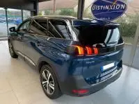 Vue 3/4 arrière droite d'un Peugeot 5008 bleu célèbes 2022 avec feux arrière LED et jantes alu en showroom.