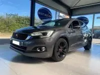 Vue 3/4 avant droite d'une DS4 gris Platinium 2017 avec jantes noires et feux LED en showroom lumineux.