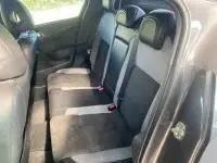 Vue intérieure arrière droite de la DS4 gris Platinium 2017, montrant les sièges arrière en tissu et cuir avec ceintures rouges.