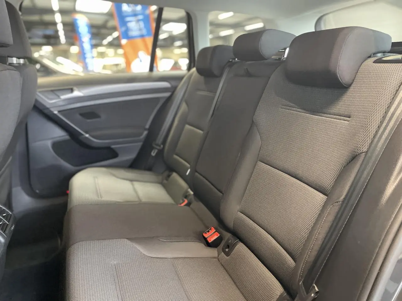Banquette arrière en tissu gris foncé de la Volkswagen Golf SW 2017, vue côté droit avec appuie-têtes et ceintures 3 points.