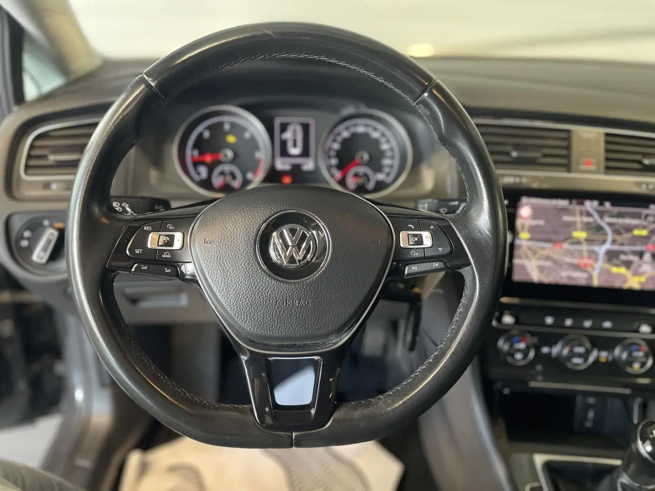 Volant en cuir noir de Volkswagen Golf SW 2017 avec tableau de bord et écran tactile de navigation visible.