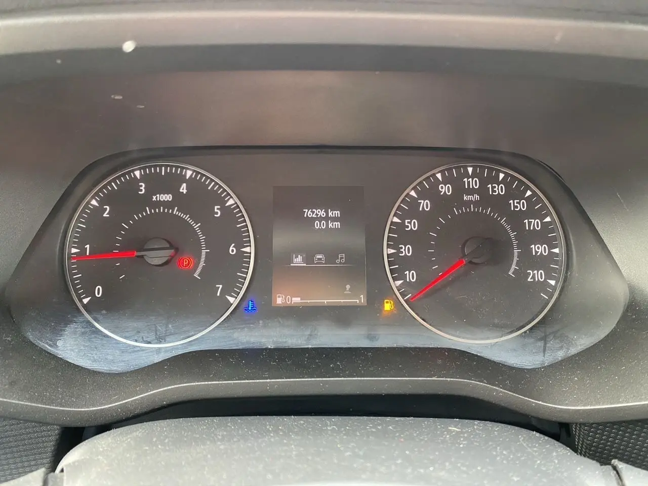 Vue rapprochée du tableau de bord du Renault Trafic Combi gris platine, affichant le compteur et l'odomètre à 76 296 km.