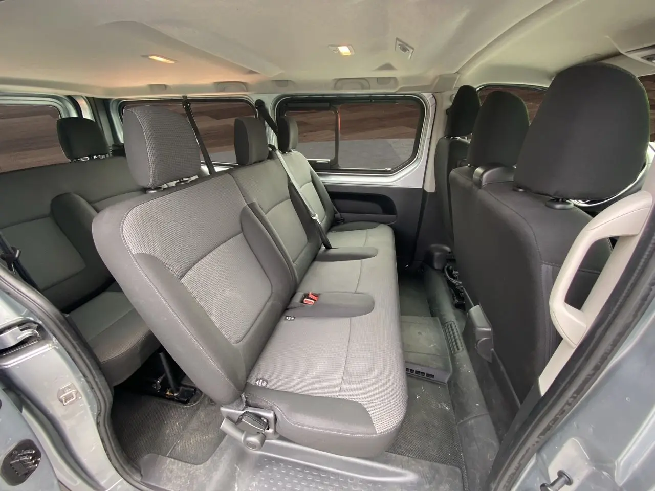 Vue intérieure côté droit sur la banquette arrière en tissu gris du Renault Trafic Combi L2 9 places, finition 2023.