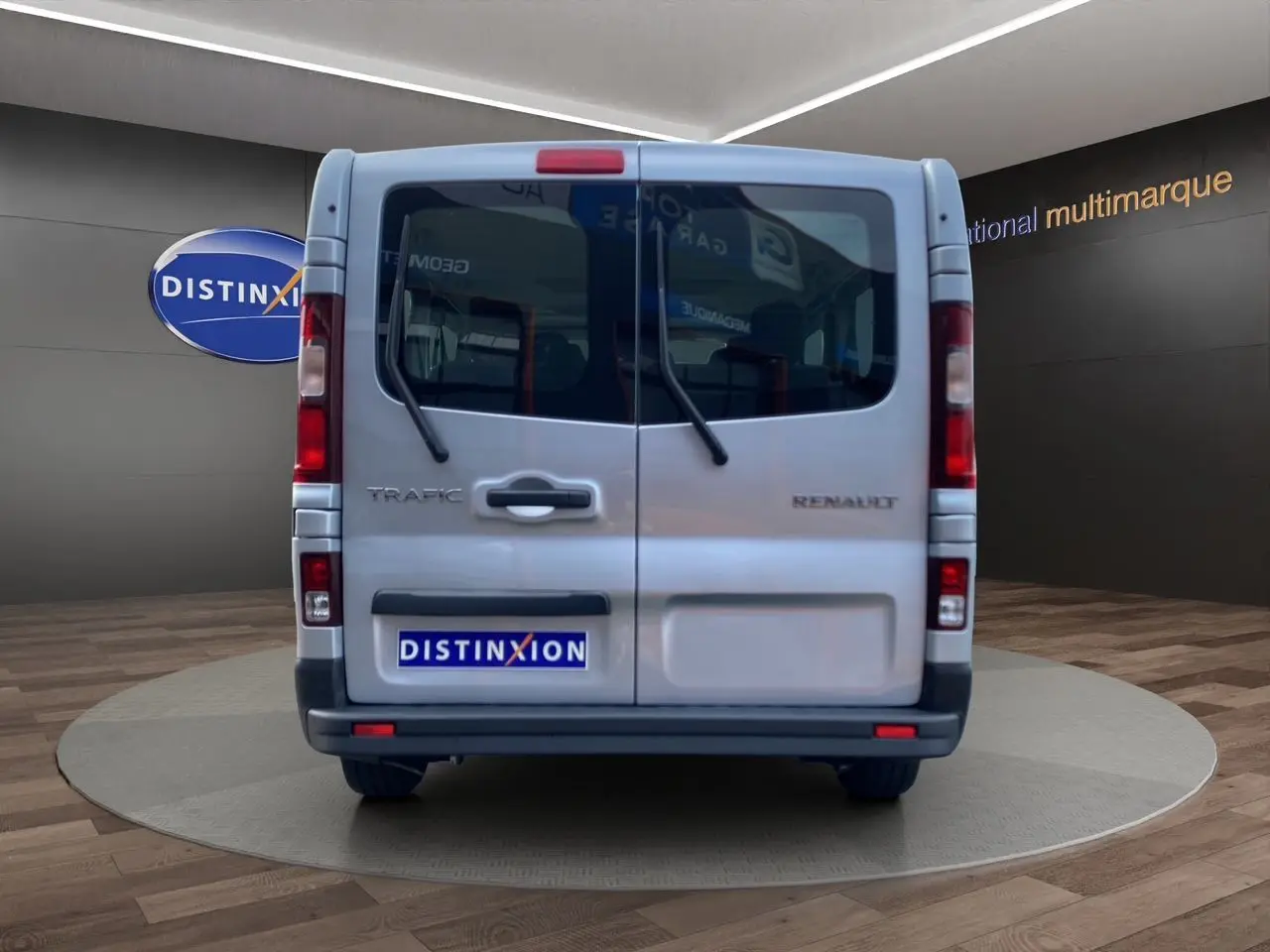Vue arrière du Renault Trafic Combi gris platine 2023, avec portes battantes et essuie-glaces arrière visibles.