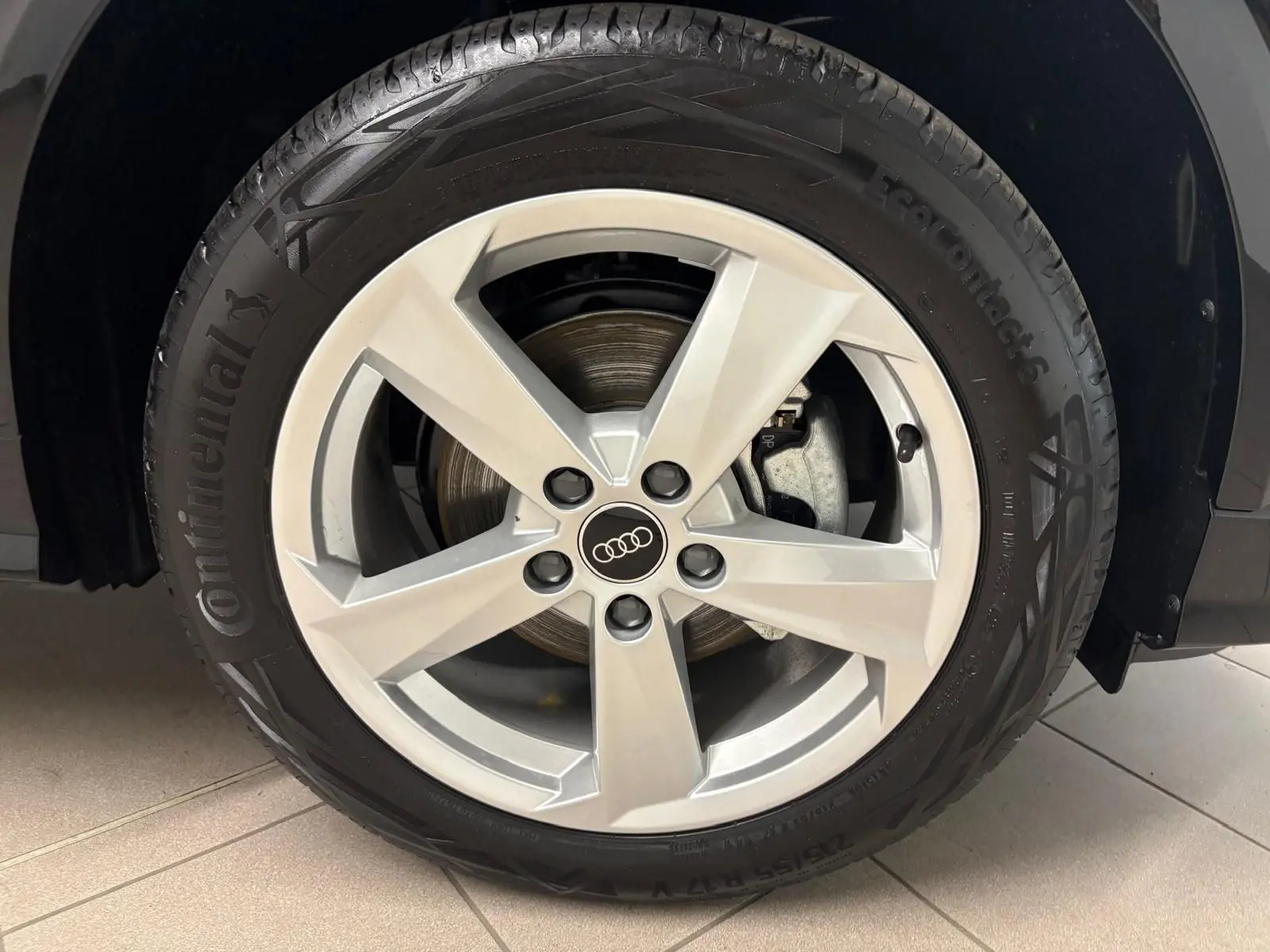 Gros plan sur la roue avant droite d’un Audi Q2 Noir Mythic avec jante alliage argentée cinq branches.