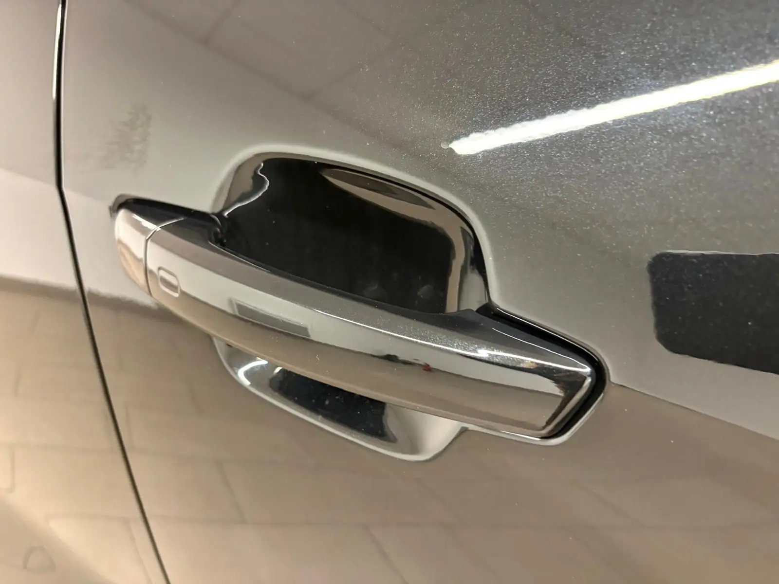 Poignée de porte chromée sur la porte avant gauche d’un Audi Q2 35 TFSI 150 S tronic 7 S line noir mythic.