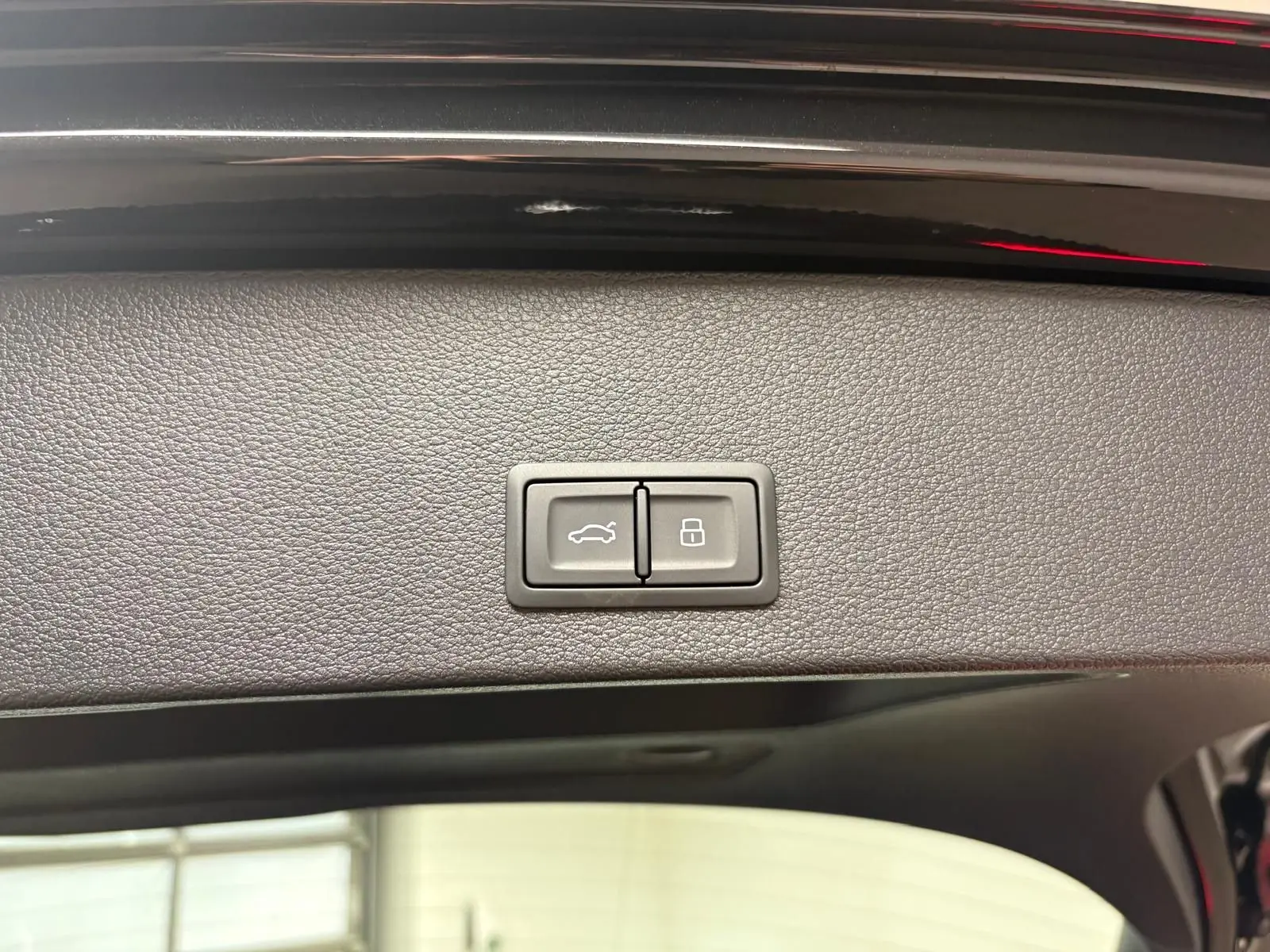 Gros plan sur les boutons du hayon électrique de l'Audi Q2 35 TFSI S Line noir Mythic, vue intérieure arrière.