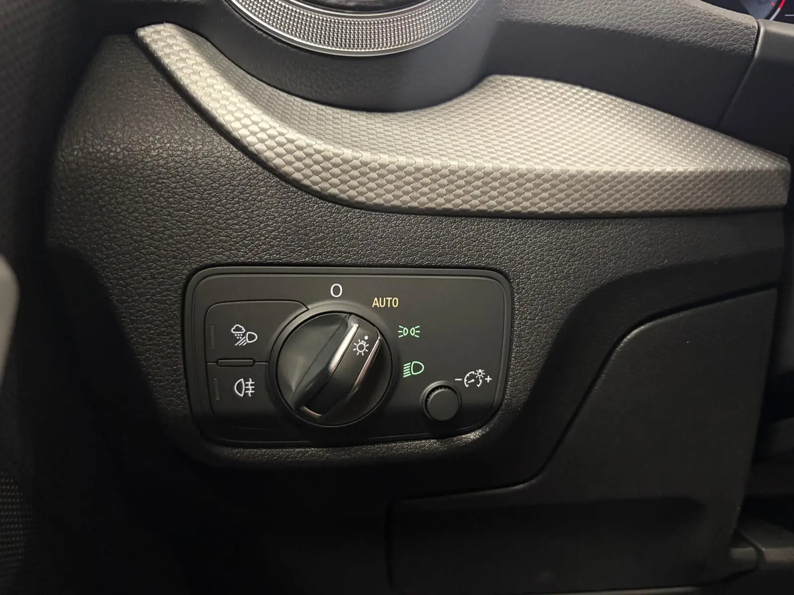 Gros plan sur le bouton de commande des phares dans l’habitacle noir de l’Audi Q2 35 TFSI S Line 2026.
