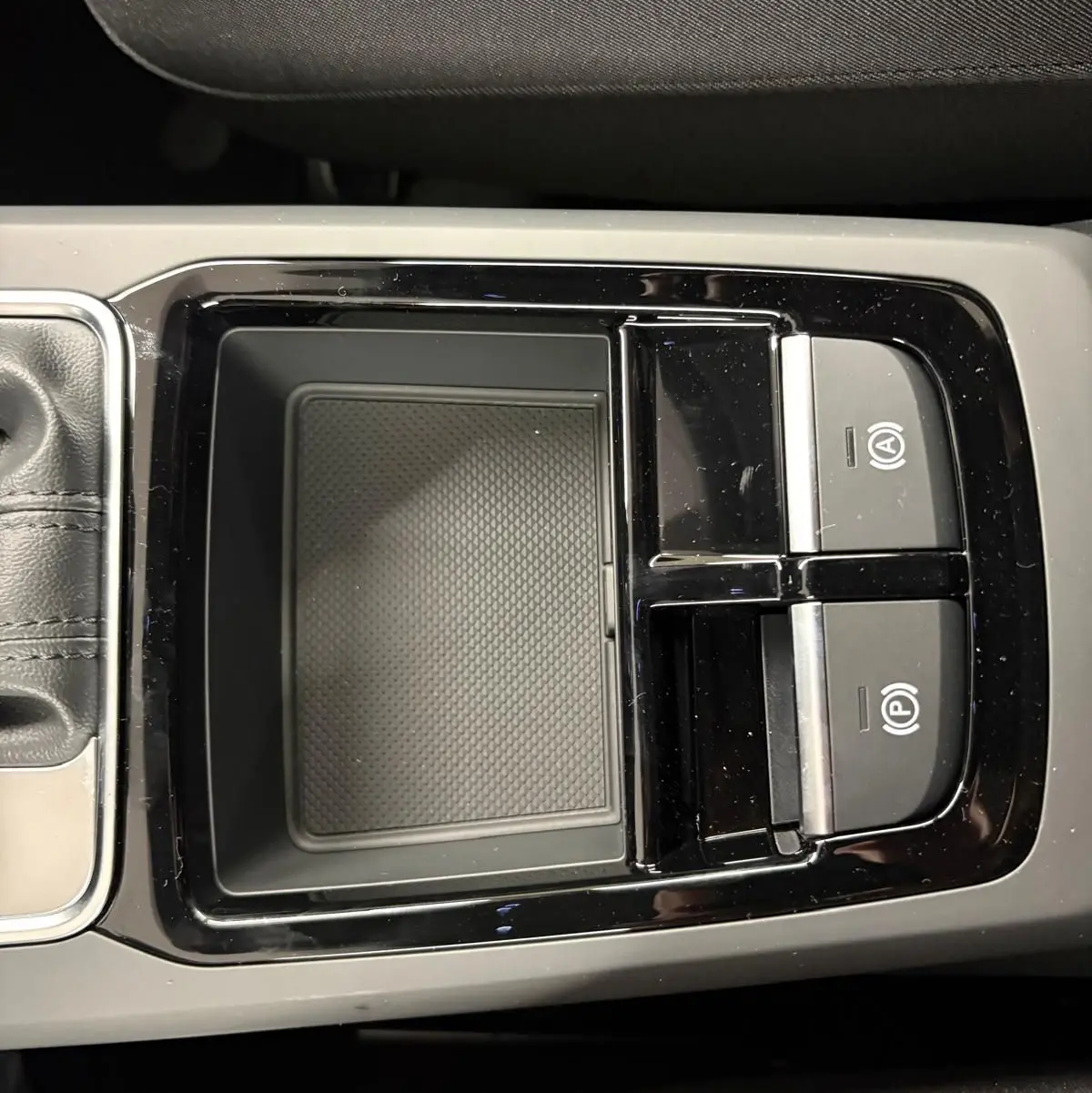 Vue rapprochée de la console centrale noire avec commandes de frein de parking et rangement, intérieur Audi Q2 2026.