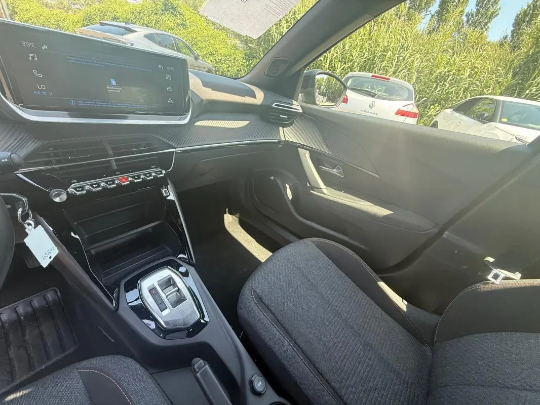 Intérieur avant droit du Peugeot 2008 Hybrid 136 e-DCS6 Style 2025 noir, avec écran tactile et console centrale brillante.