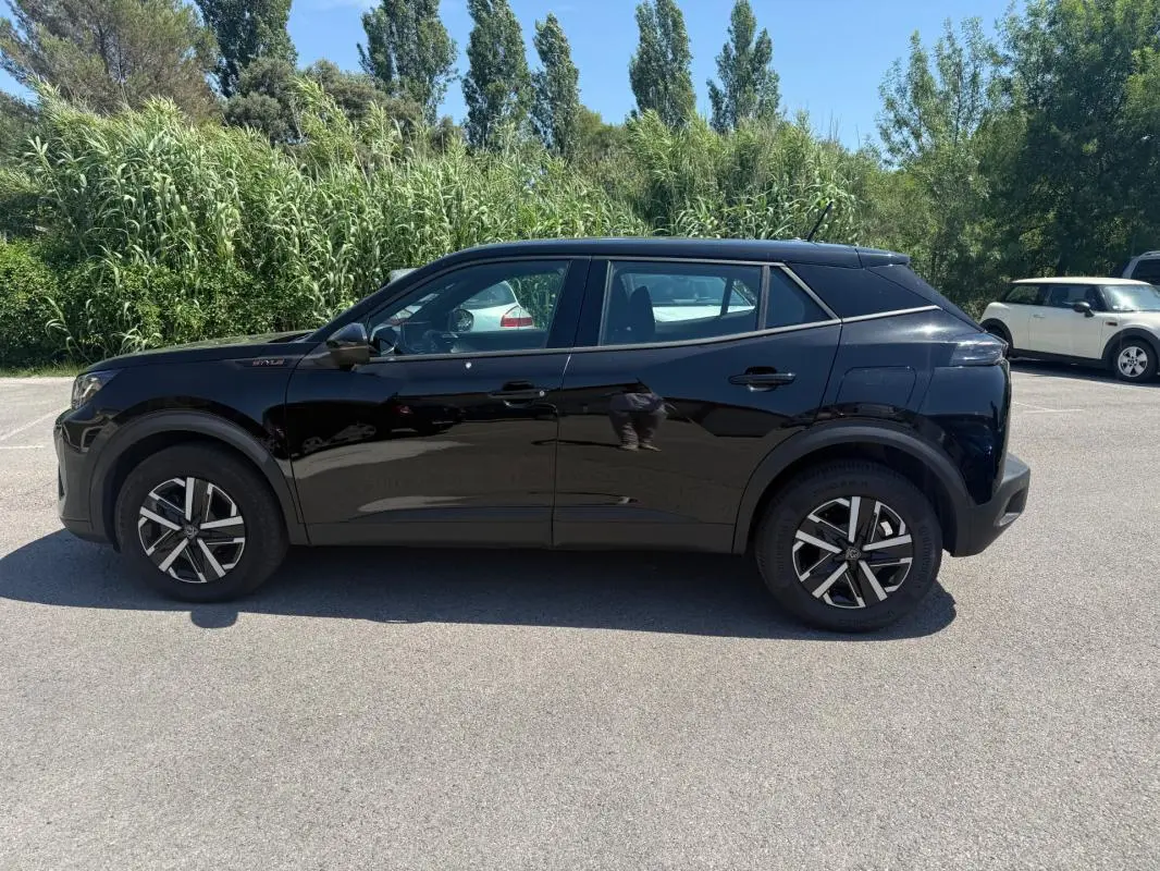 Peugeot 2008 Hybrid noir vue de profil côté gauche, jantes 16 pouces et lignes modernes soulignées.