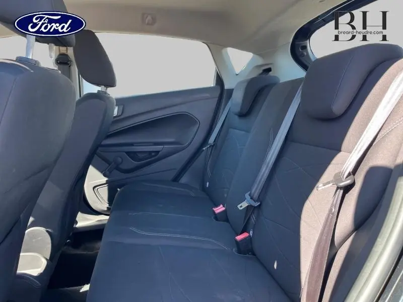 Vue intérieure de la banquette arrière noire de la Ford Fiesta 2015, côté droit avec ceintures de sécurité visibles.