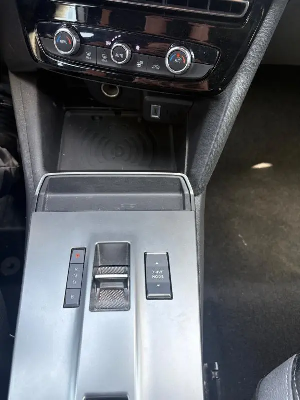 Vue rapprochée de la console centrale grise de l’Opel Mokka électrique 2025 avec commandes de boîte auto et climatisation.