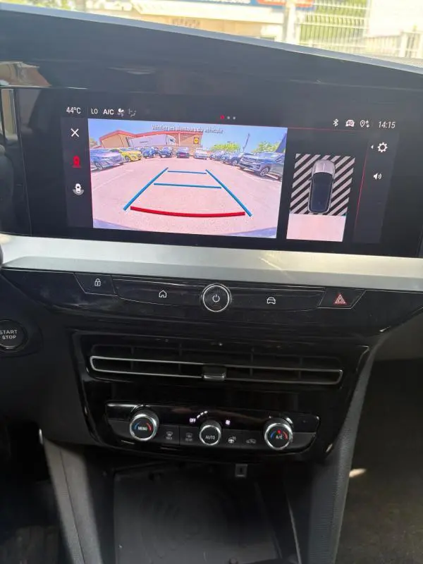 Vue intérieure de l'Opel Mokka électrique 2025, écran tactile affichant la caméra de recul et commandes climatisation.