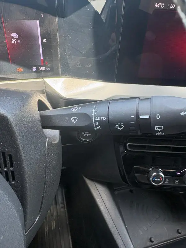 Gros plan sur la commande des essuie-glaces à gauche du volant dans l'habitacle d'un Opel Mokka électrique gris 2025.