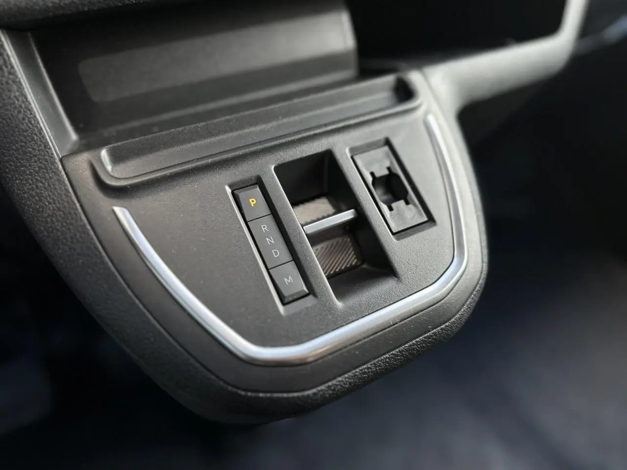 Gros plan sur la console centrale noire du Fiat Scudo Fourgon 2024 montrant la commande de boîte automatique et un emplacement vide.