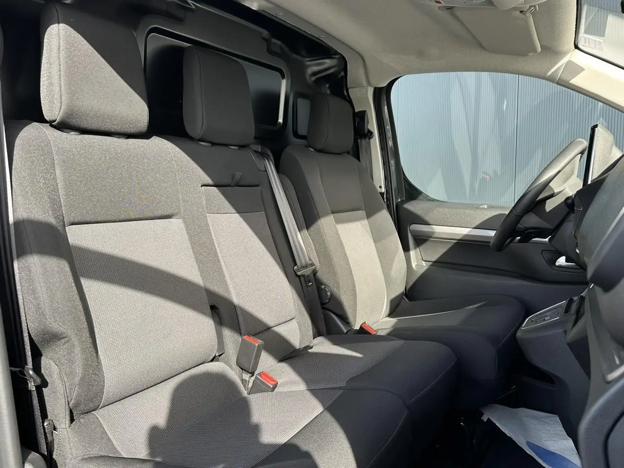 Vue intérieure côté droit sur la banquette passager 2 places en tissu bi-ton gris du FIAT Scudo Fourgon 2024.
