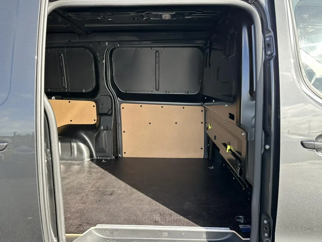 Vue intérieure de la zone de chargement du FIAT Scudo Fourgon gris Platinium, avec plancher antidérapant et parois protégées.