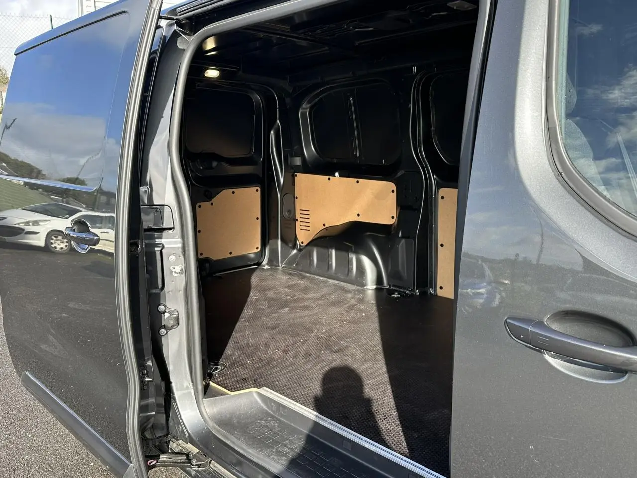 Vue latérale droite du FIAT Scudo Fourgon gris Platinium avec porte coulissante ouverte montrant l’espace de chargement vide.