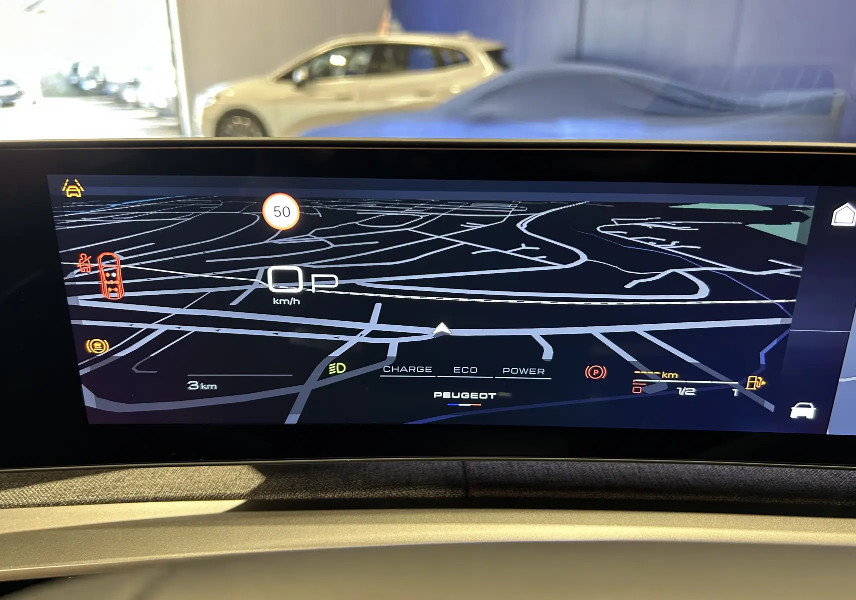 Écran de navigation intérieur du Peugeot 5008 bleu Ingaro, affichant la carte en vue frontale avec indications de vitesse et énergie.