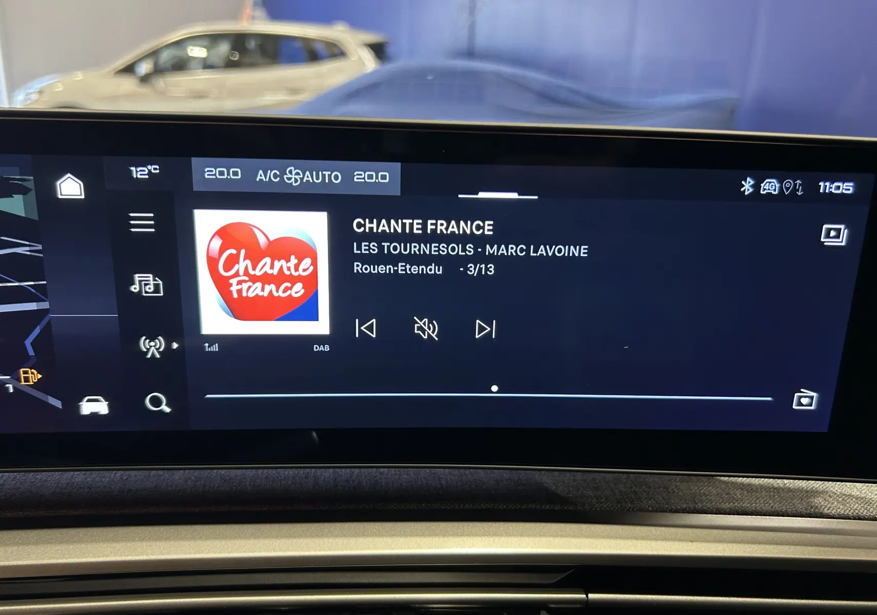 Écran tactile intérieur du Peugeot 5008 III Hybrid 145 GT affichant la radio Chante France, avec tableau de bord en arrière-plan.