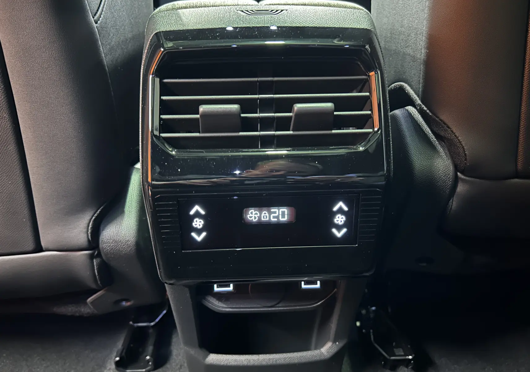 Vue rapprochée de la console arrière noire avec commandes climatisation et ports USB du Peugeot 5008 Bleu Ingaro.
