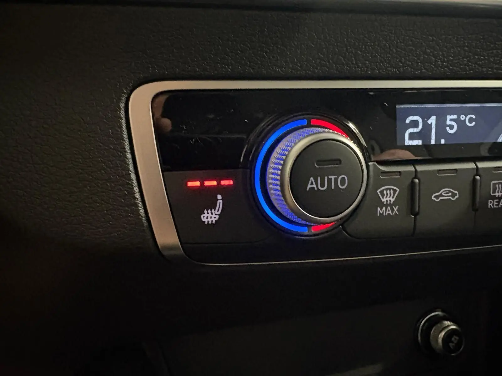 Gros plan sur le bouton de réglage de la climatisation avec fonction siège chauffant activée dans l’Audi Q2 35 TFSI S Line.