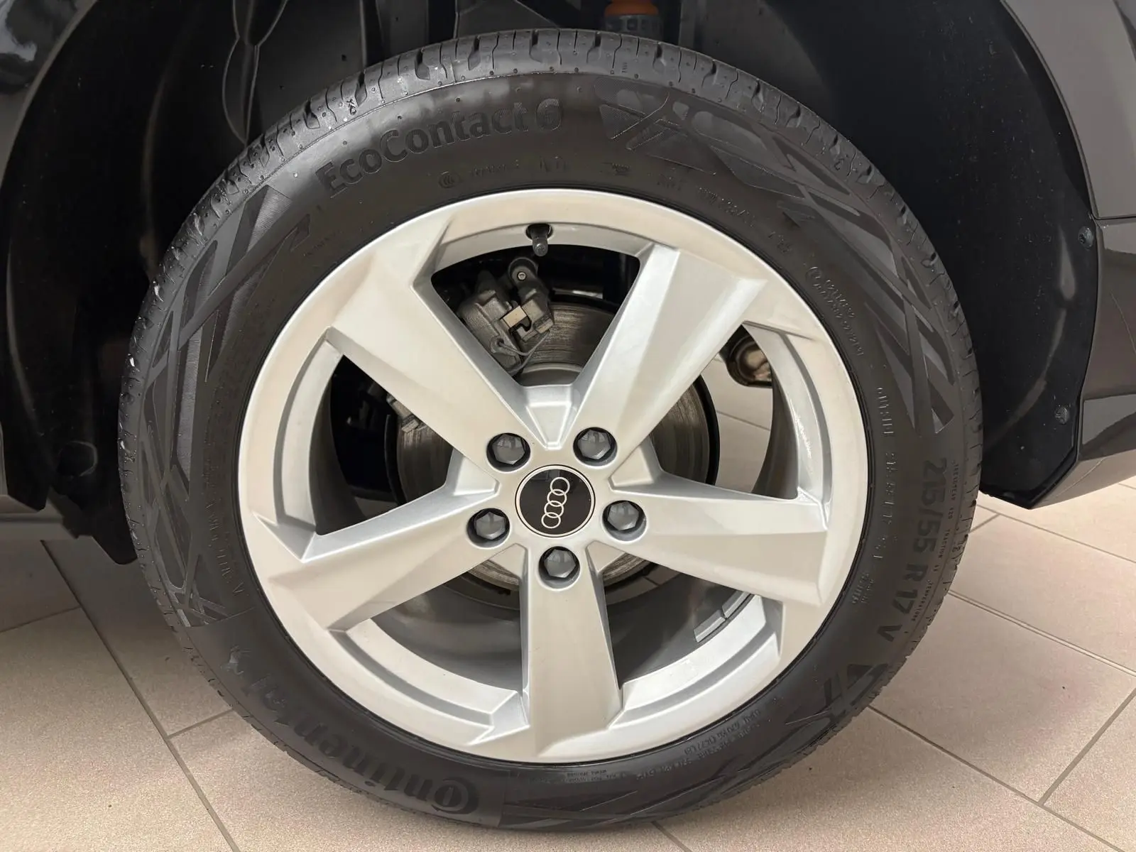 Gros plan sur la roue avant gauche de l'Audi Q2 35 TFSI S Line 2026 en Noir Mythic avec jante argentée cinq branches.