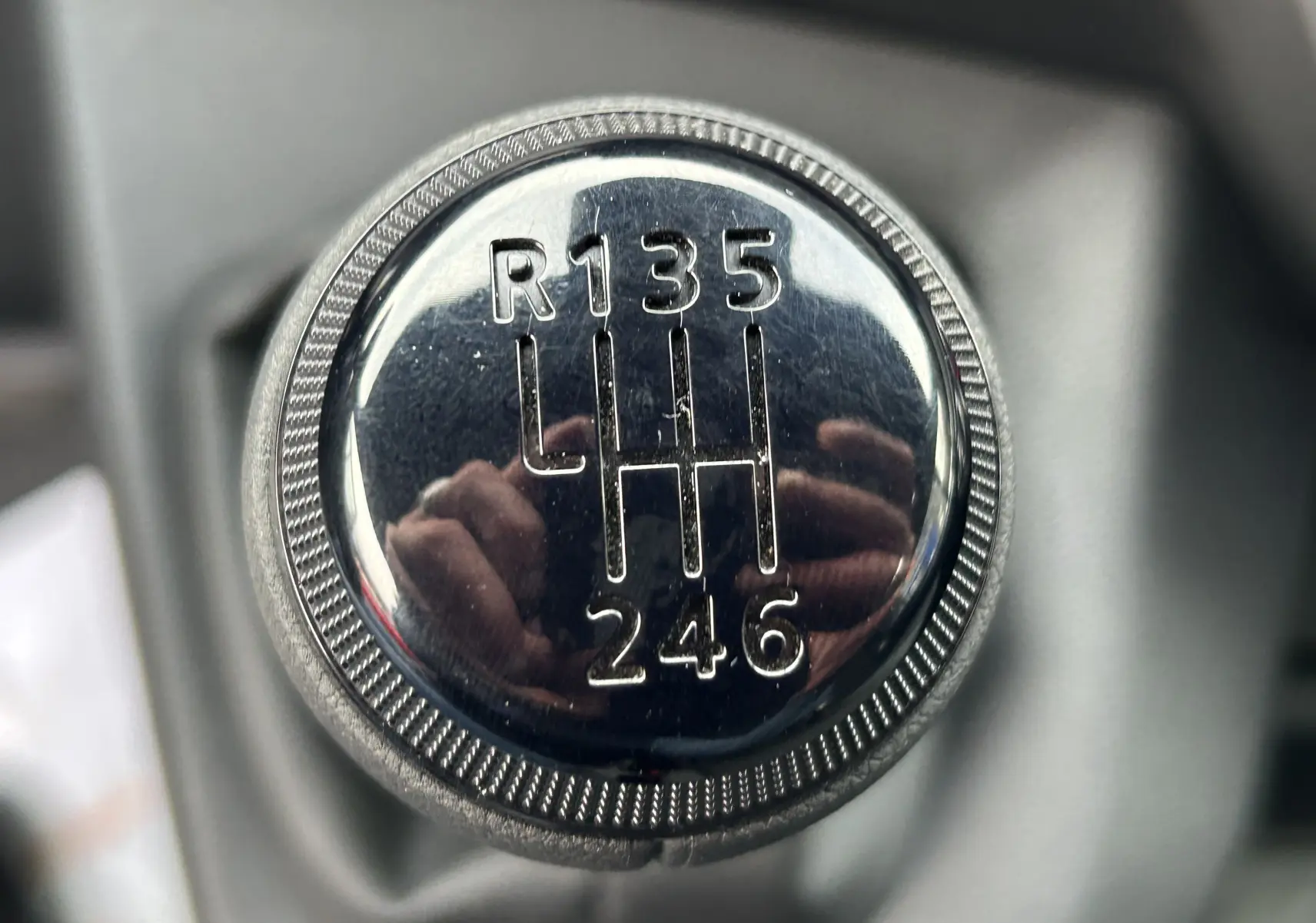 Gros plan sur le pommeau de la boîte manuelle du Renault Master blanc, montrant le schéma des 6 vitesses et la marche arrière.