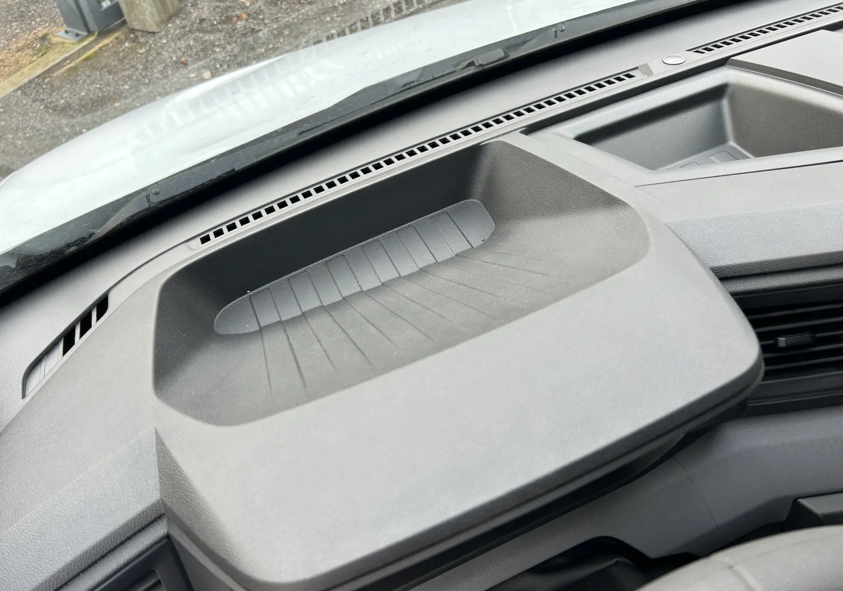 Vue rapprochée du plateau de rangement noir sur le tableau de bord du Renault Master blanc, intérieur avant.