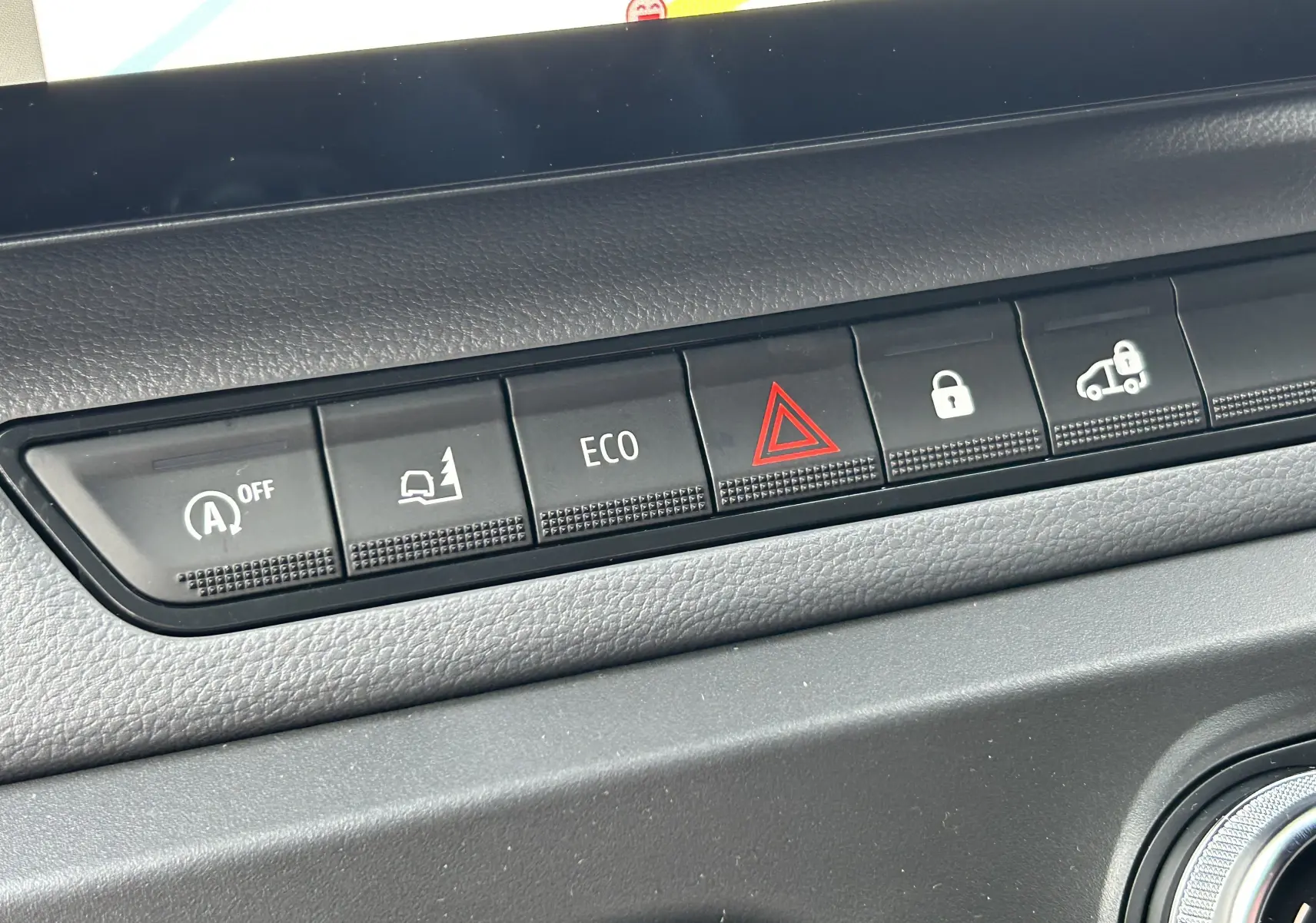 Gros plan sur la rangée de boutons de commande noirs du tableau de bord du Renault Master blanc, version 2025.