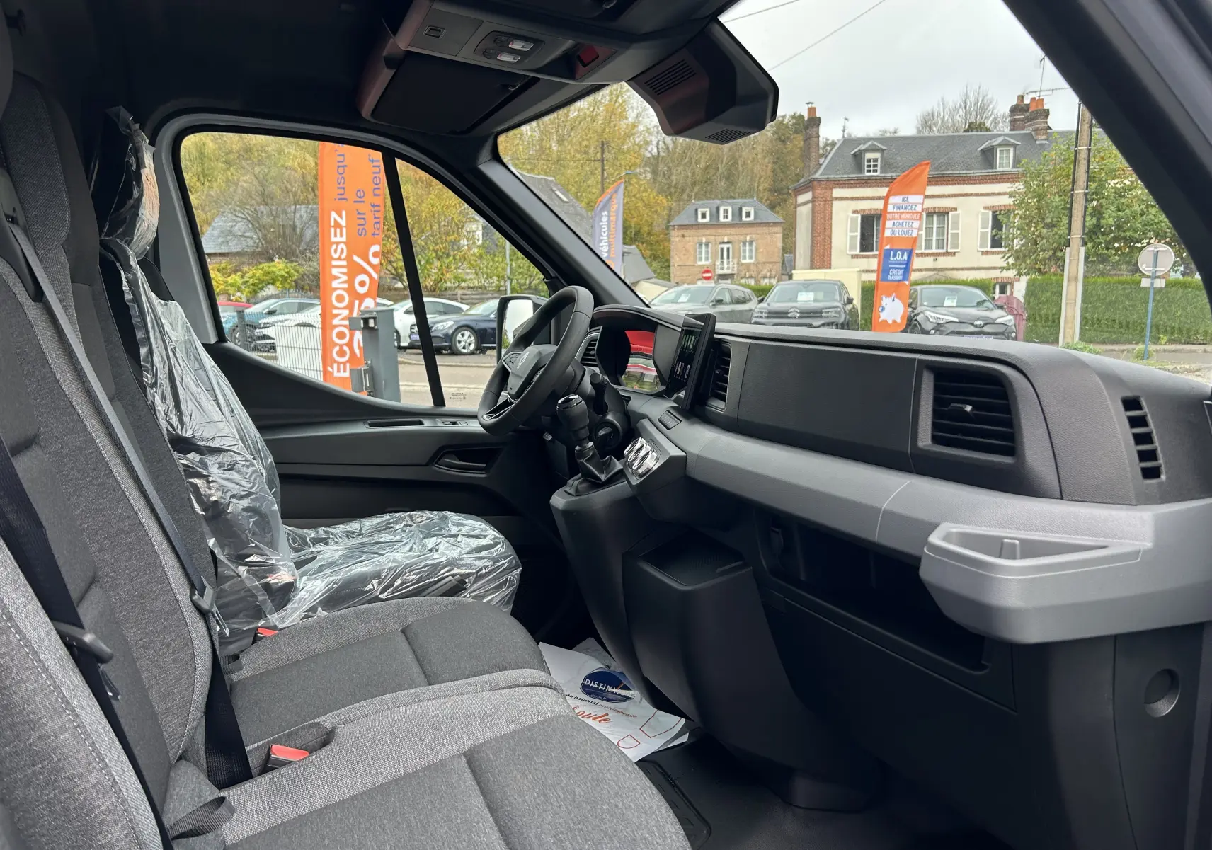 Vue intérieure côté droit du poste de conduite du Renault Master blanc 2025 avec sièges tissu et tableau de bord moderne.