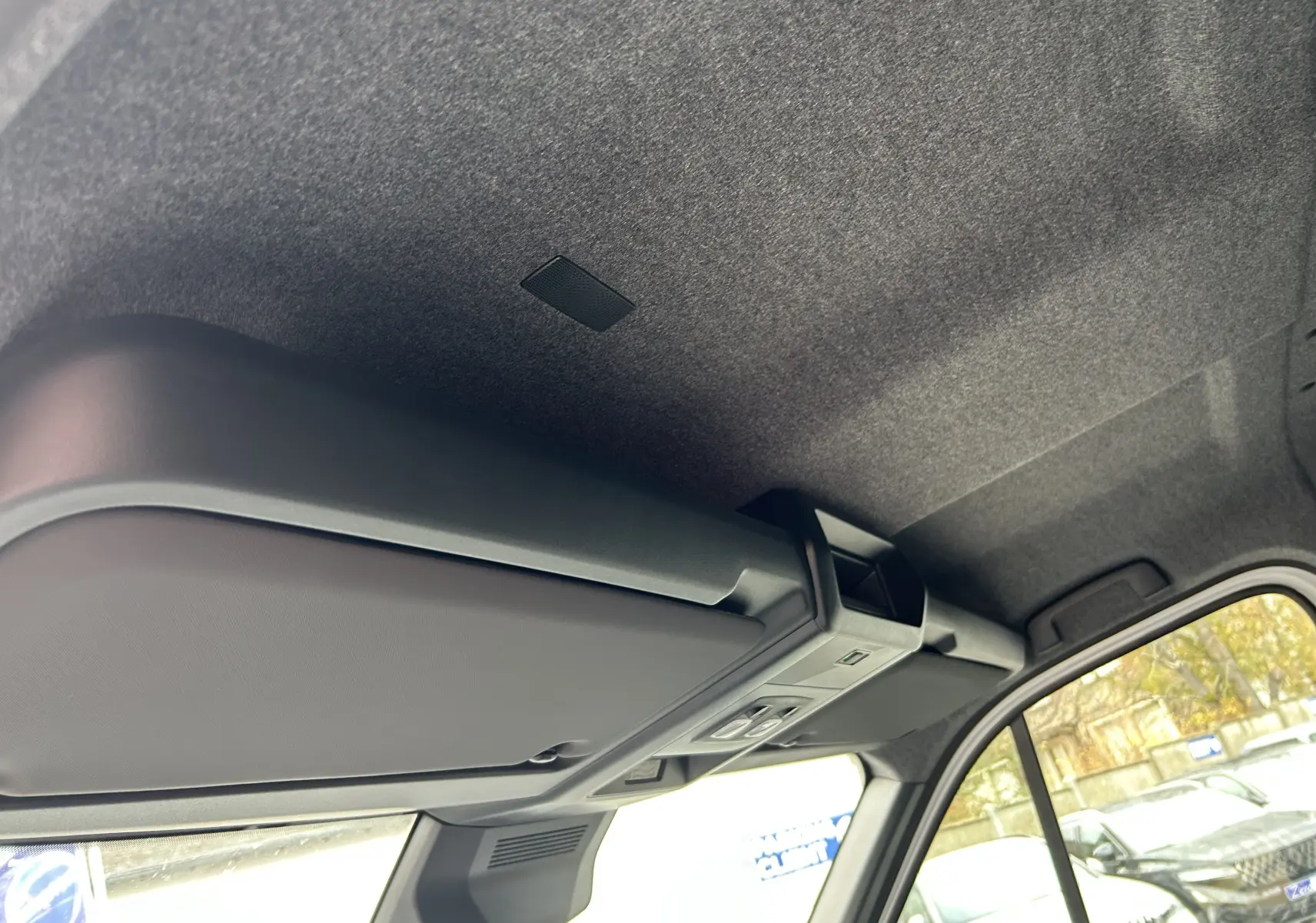 Vue intérieure du plafond et rangement au-dessus du pare-brise du Renault Master blanc, avec fenêtre latérale visible.