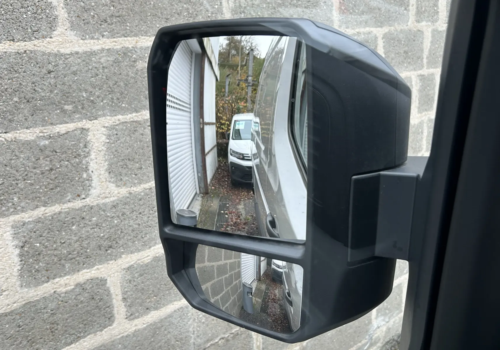 Rétroviseur latéral droit du Renault Master blanc 2025, reflétant la carrosserie et un autre fourgon blanc derrière.