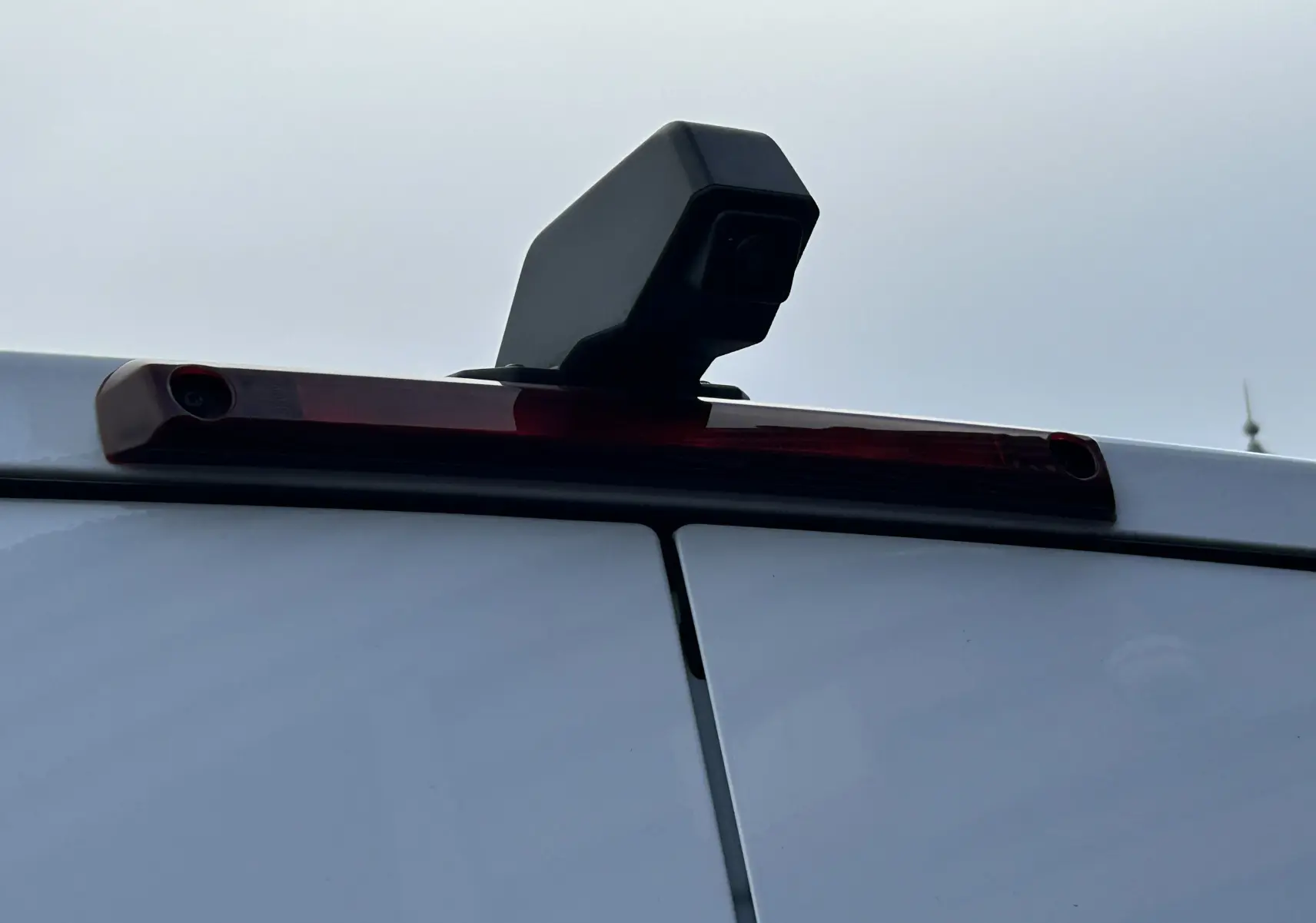 Gros plan sur la caméra de recul noire fixée au-dessus des portes arrière blanches du Renault Master IV L2H2.