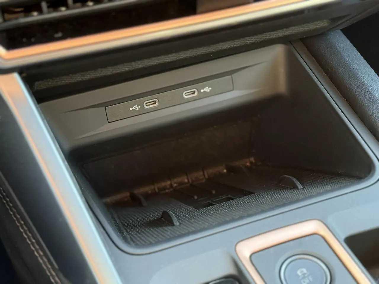 Gros plan sur la console centrale noire du CUPRA LEON ST 2025 avec deux ports USB-C intégrés et surface texturée.
