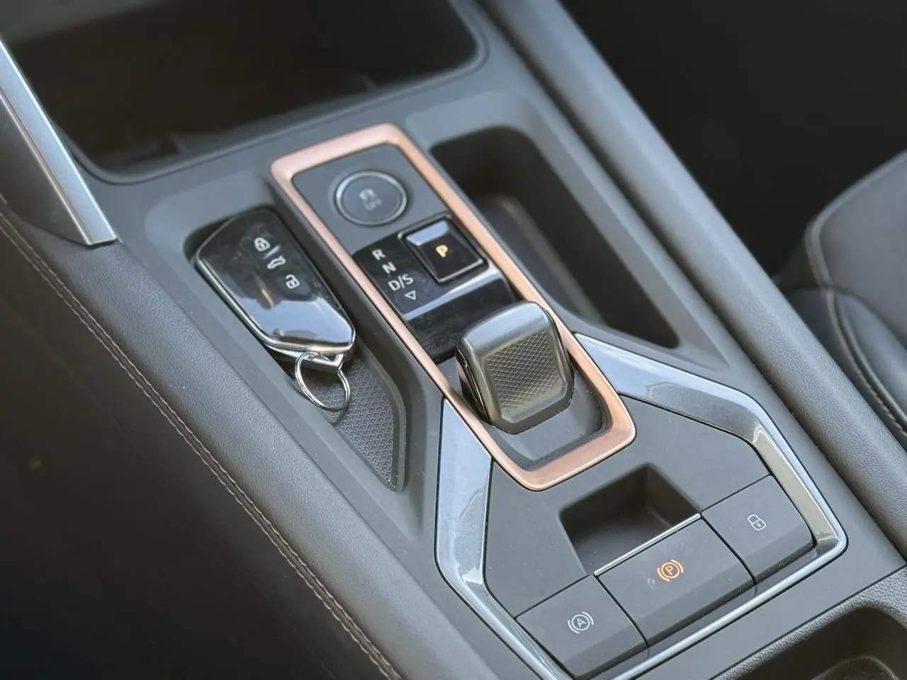 Gros plan sur la console centrale noire du CUPRA LEON ST 2025 avec levier de boîte auto et clé posée.