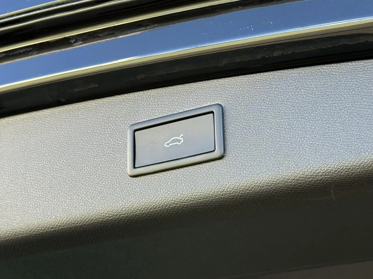 Bouton d'ouverture électrique du hayon sur la partie intérieure du coffre d'une CUPRA LEON ST noir Midnight 2025.