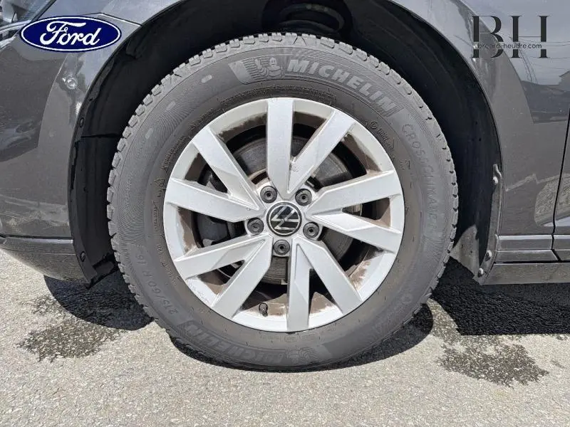Gros plan sur la roue avant gauche d'une Volkswagen Passat SW gris manganèse avec jante alu et pneu Michelin.