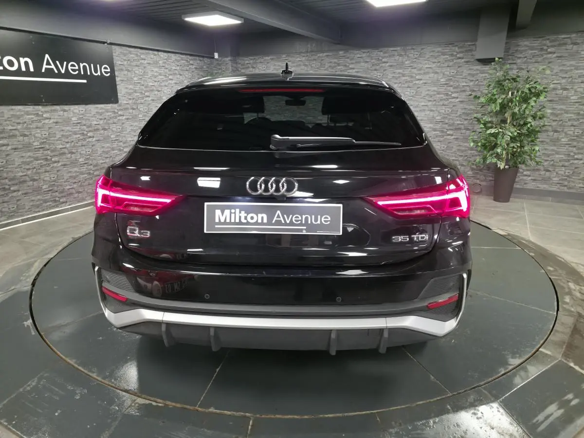 Vue arrière d'un Audi Q3 Sportback noir 2023 avec feux LED allumés et logo 35 TDI visible.