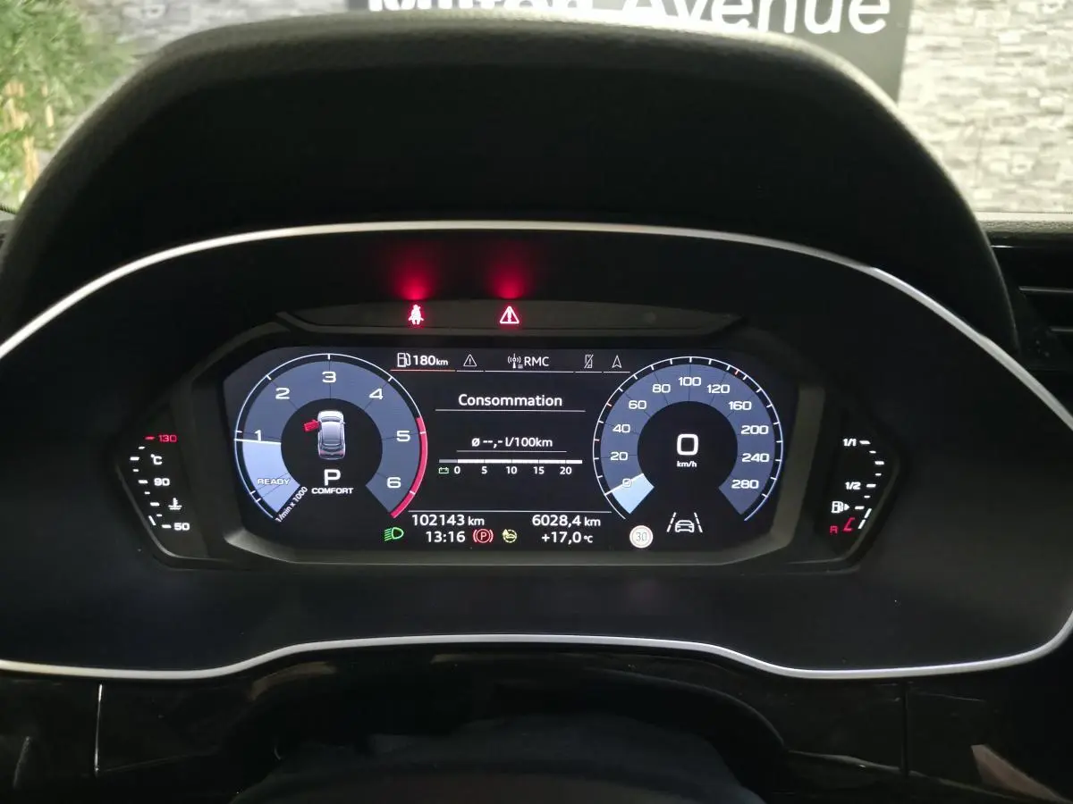 Vue rapprochée du combiné d'instruments numérique de l'Audi Q3 Sportback noir, affichant la consommation et la vitesse à 0 km/h.