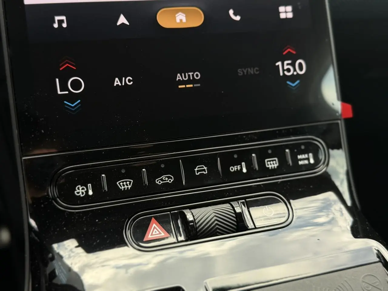 Gros plan sur la console centrale noire brillante du Citroën C5 Aircross avec commandes climatisation et bouton warning.