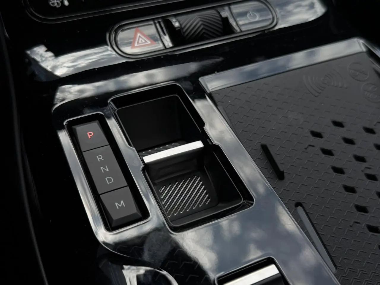 Gros plan sur la console centrale noire brillante du Citroën C5 Aircross hybride avec sélecteur de vitesses automatique.