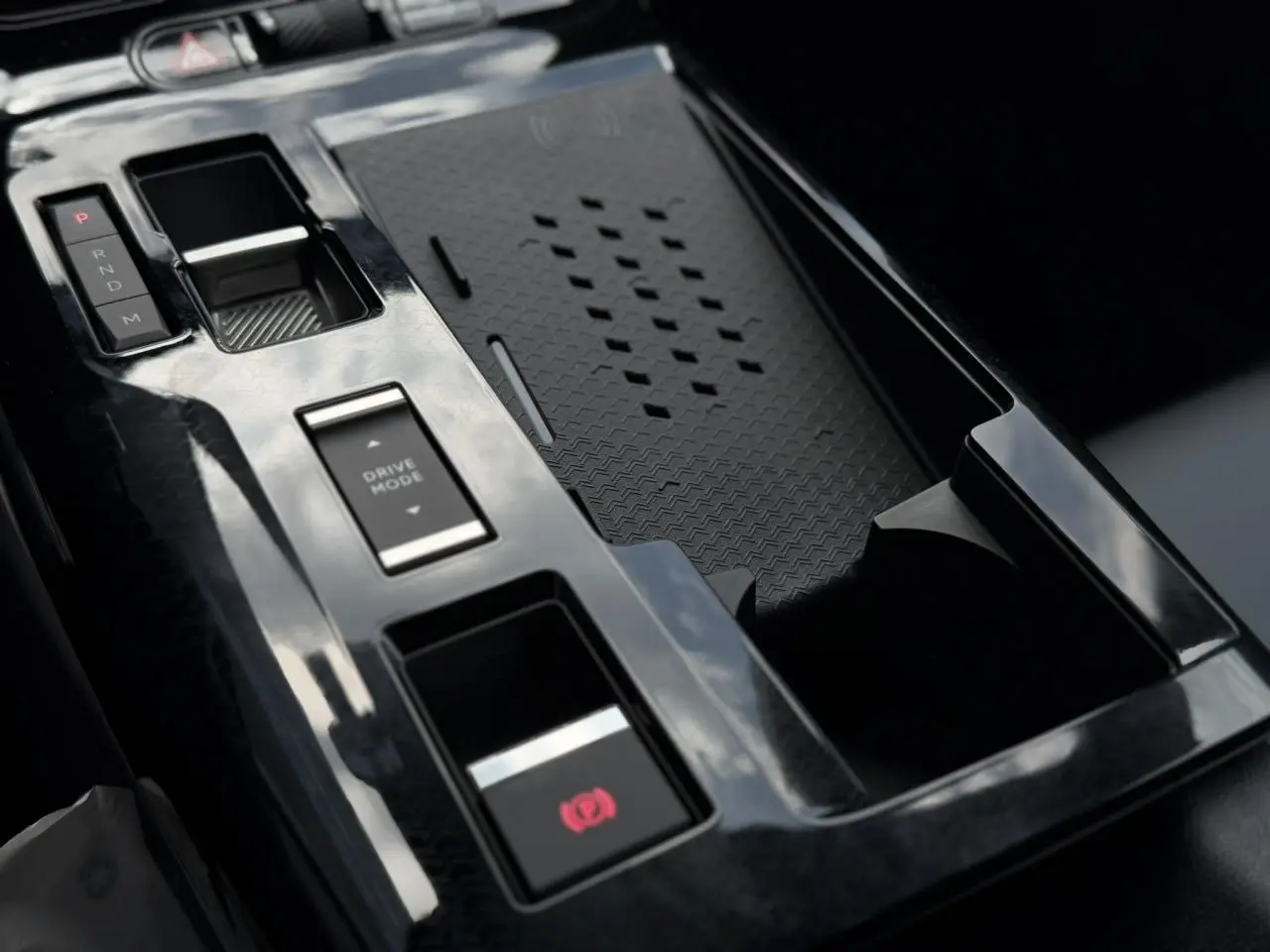 Gros plan sur la console centrale noire brillante du Citroën C5 Aircross Hybrid avec commandes de boîte auto et mode de conduite.