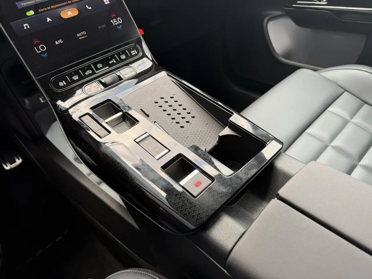 Vue rapprochée de la console centrale noire brillante avec commandes tactiles et siège gris clair du Citroën C5 Aircross.