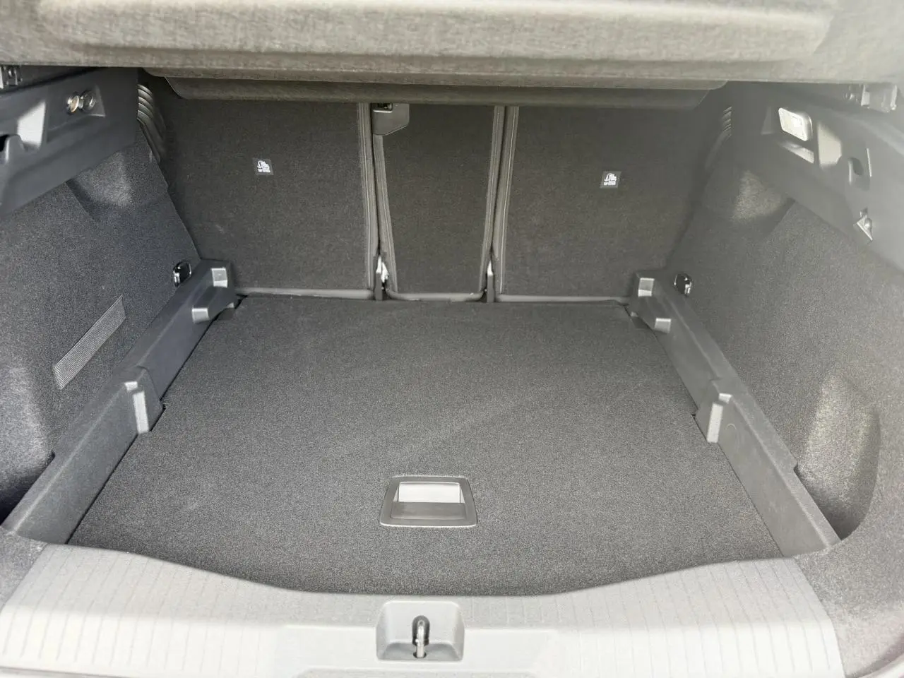 Coffre spacieux du Citroën C5 Aircross hybride 2026, vue intérieure arrière avec plancher modulable et revêtement noir.