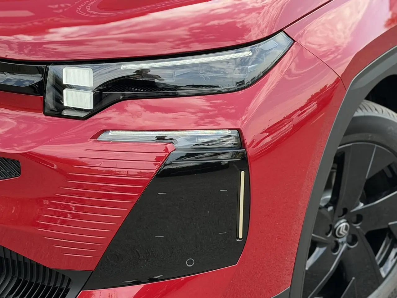 Gros plan sur l'avant droit rouge rubis du Citroën C5 Aircross avec optique LED et jante alliage noire.