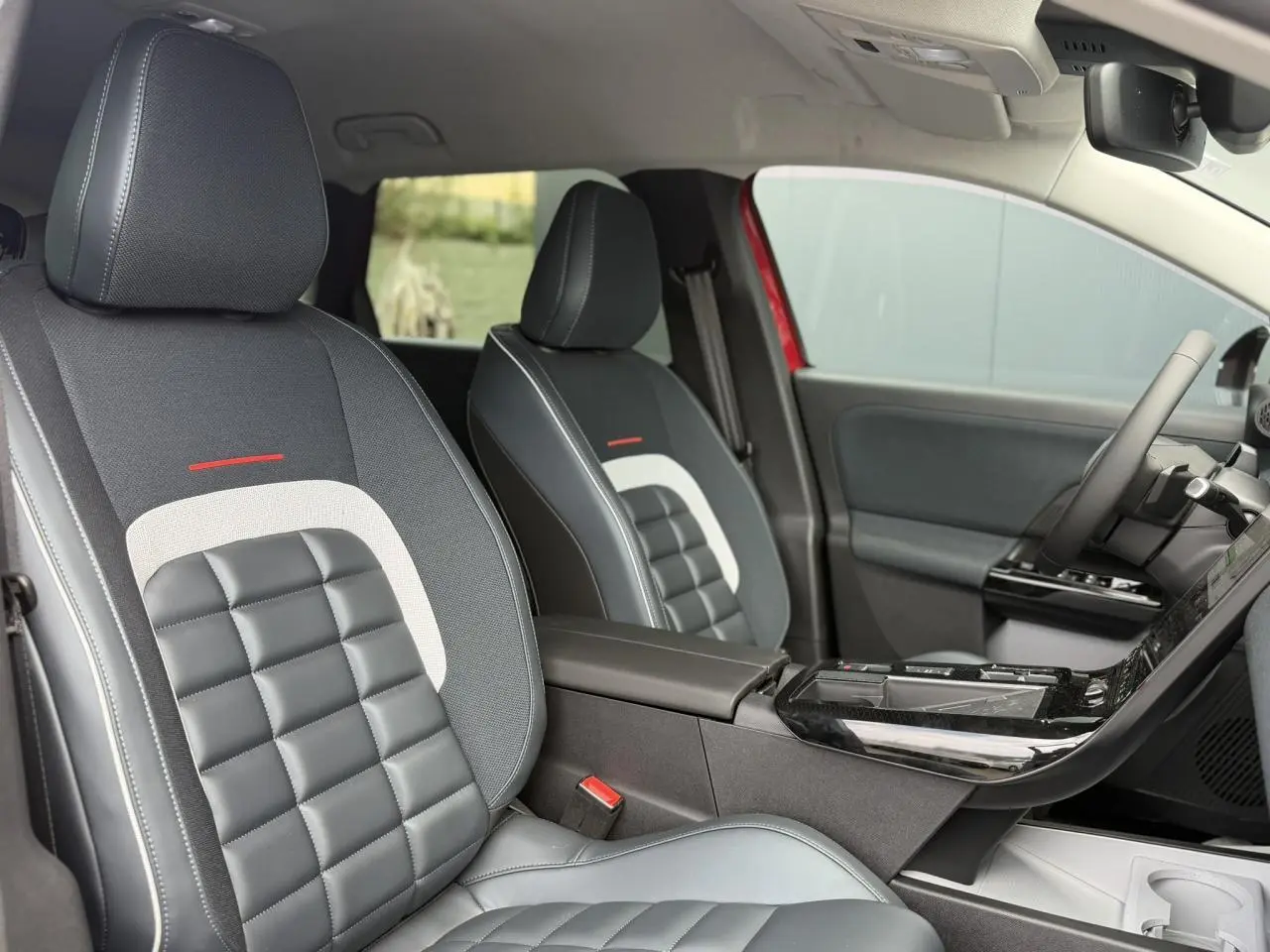 Vue intérieure côté droit des sièges avant en tissu et cuir noir avec inserts gris et détails rouges du Citroën C5 Aircross 2026.
