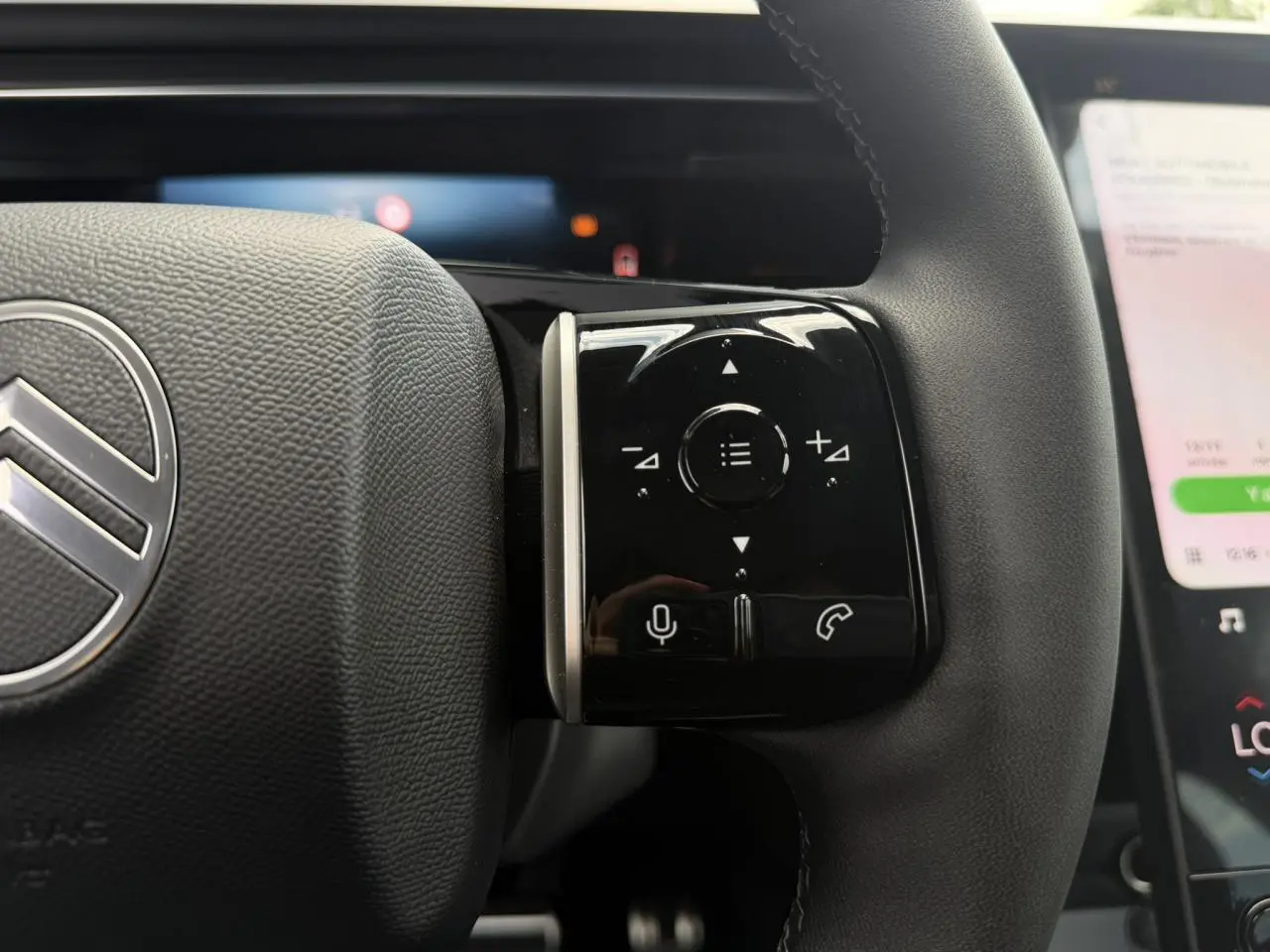 Gros plan sur les commandes tactiles noires à droite du volant gris foncé du Citroën C5 Aircross hybride 2026.
